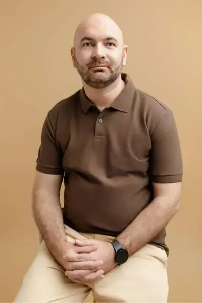 Anderson dos Santos sentado, em retrato com fundo claro